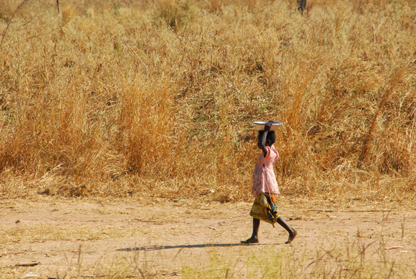 Young girl carrying a small pot
